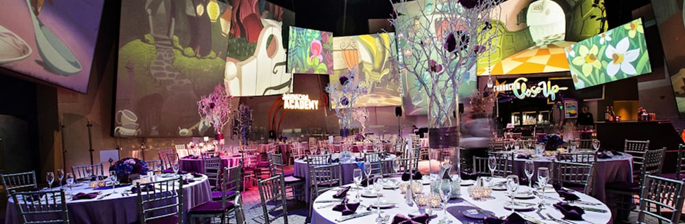 Round tables arranged in a room with large pictures showing scenes from 'Alice in Wonderland'