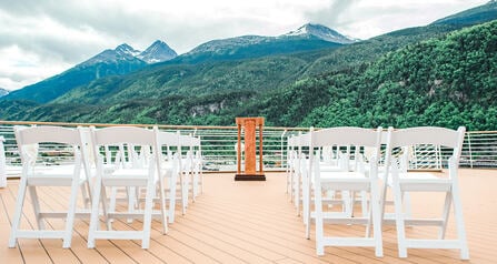 Several rows of chairs facing a podium on an outdoor patio area