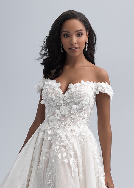 A close up look at a flowered bodice on a wedding with dress with an off the shoulder neckline