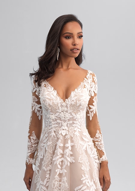 A woman wearing a long sleeved wedding gown covered of leafy lace patterns A woman wearing a long sleeved wedding gown covered of leafy lace patterns