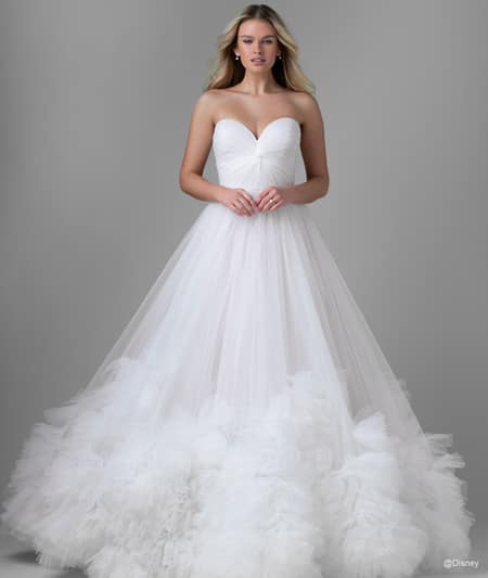 The front of a bride wearing a Rapunzel inspired ball gown featuring a sweetheart neckline and ruffles around the hem