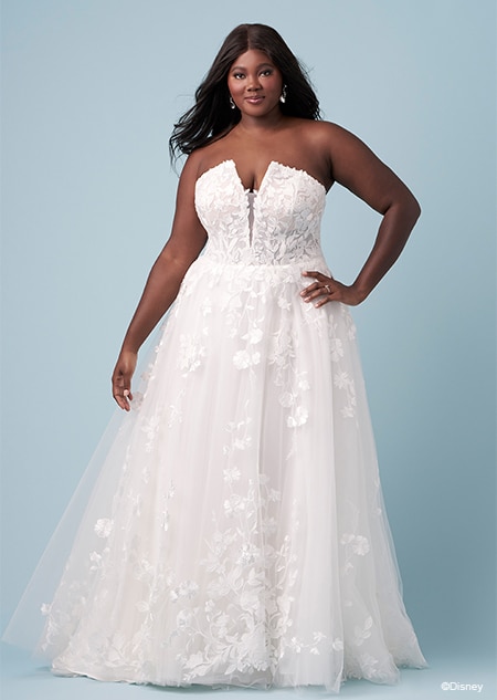 A bride wearing a Pocahontas inspired A line wedding gown featuring a plunging illusion neckline and embroidery of leaves and blossoms