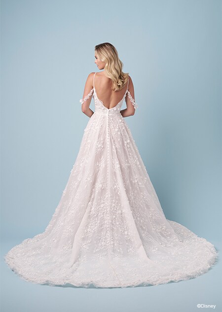 The back of a bride wearing a Snow White inspired A line wedding gown featuring embroidery, spaghetti straps, an exposed back and lace off the shoulder sleeves