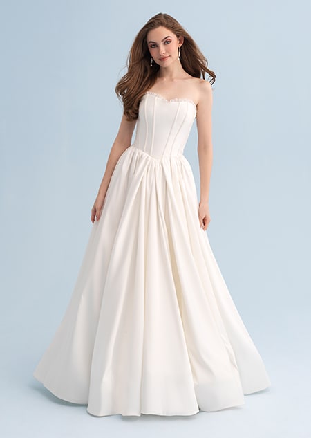 A woman wearing a strapless wedding dress with a full skirt A woman wearing a strapless wedding dress with a full skirt