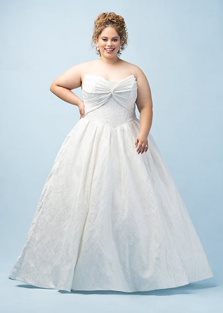 The front of a bride wearing an Aurora inspired ball gown featuring a straight neckline and a bodice with a bow