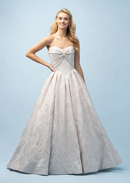 The front of a bride wearing an Aurora inspired ball gown featuring a straight neckline and a bodice with a bow