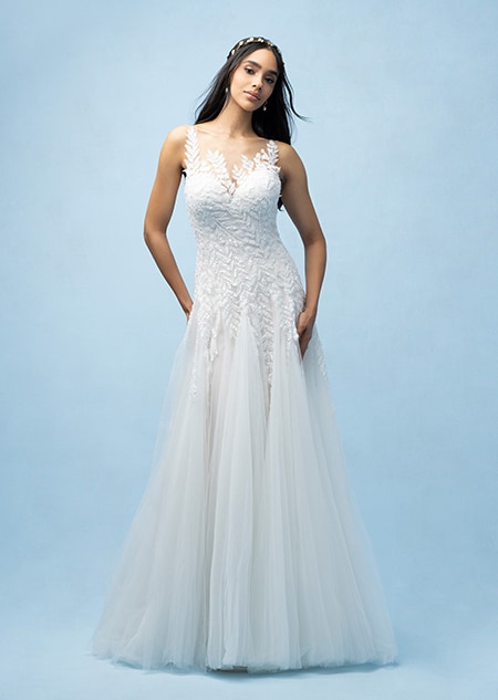 The front of a bride wearing a Pocahontas inspired A line gown featuring a sweetheart neckline and a bodice and straps with a beaded leaf design The front of a bride wearing a Pocahontas inspired A line gown featuring a sweetheart neckline and a bodice and straps with a beaded leaf design