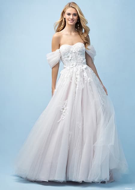 The front of a bride wearing a Rapunzel inspired A line gown featuring an off the shoulder neckline and lace flowers on the bodice and skirt