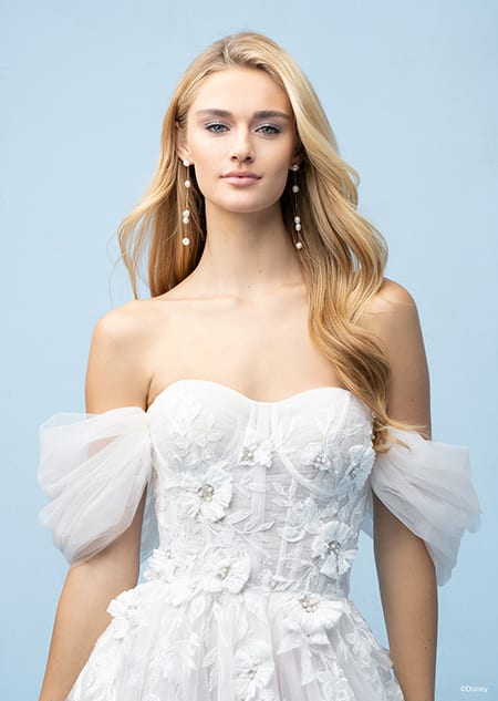 The bodice of a bride wearing a Rapunzel inspired A line gown featuring an off the shoulder neckline and lace flowers