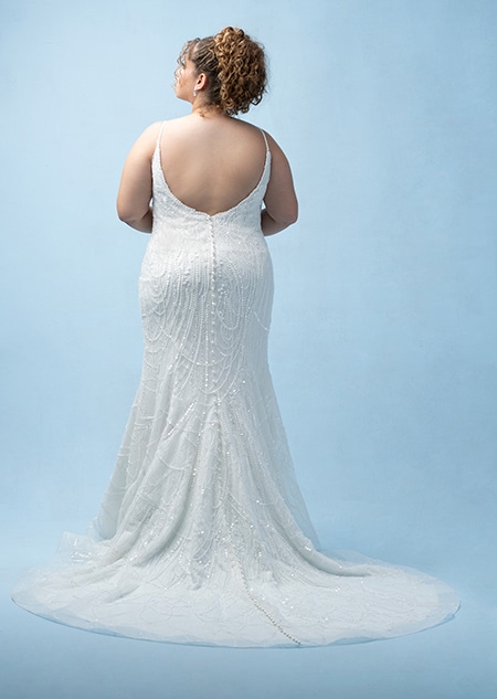 The back of a bride wearing a Tiana inspired sheath gown featuring beading, sequins, a train and spaghetti straps The back of a bride wearing a Tiana inspired sheath gown featuring beading, sequins, a train and spaghetti straps