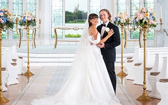 A couple posing at the altar in Disney's Wedding Pavilion