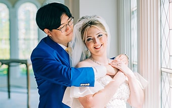 A smiling couple near a window inside Disney's Wedding Pavilion