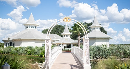 A manicured garden with a trellis and a path leading to a wedding pavilion at Disney’s Grand Floridian Resort & Spa 