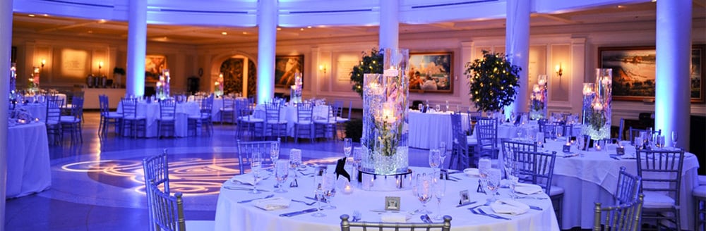 Tall glass centerpieces on round tables in the rotunda at the American Adventure attraction
