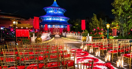 A wedding ceremony setting decorated with candles and an aisle of rose petals at the China Pavilion