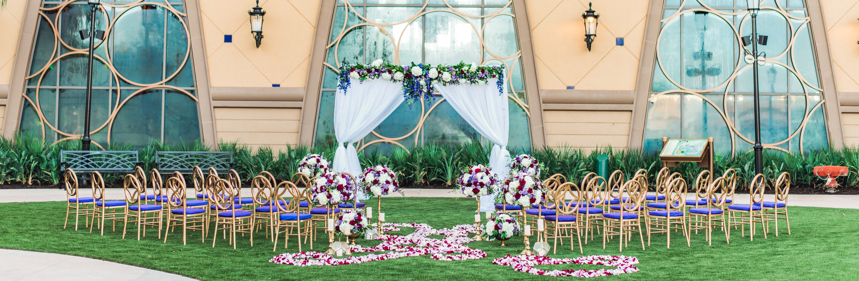 Chairs arranged on lawn facing a large building with many windows and floral decorations