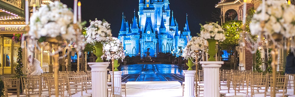 Rows of chairs and flowers arranged for a wedding ceremony with a castle as the backdrop
