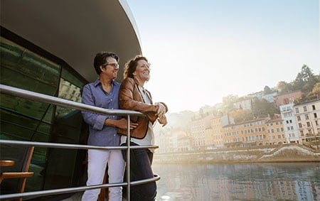 A couple embracing and admiring the city while on a river cruise