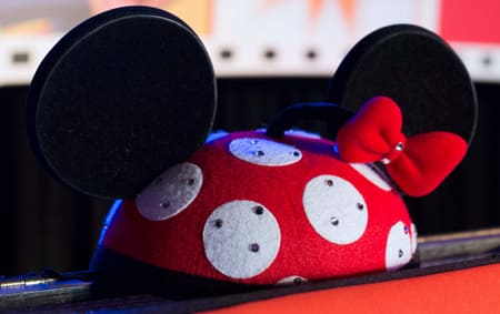 A Minnie Mouse ear hat with polka dots and a bow that are studded with rhinestones