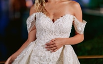 A woman wearing a lacy off the shoulder sparkly wedding dress 