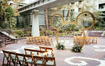 Courtyard wedding seating under a monorail crossing with a large Mickey Mouse arch centerpiece