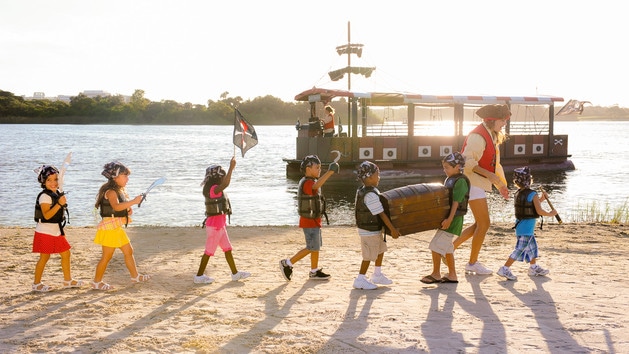 Children dressed in pirate attire on a beach