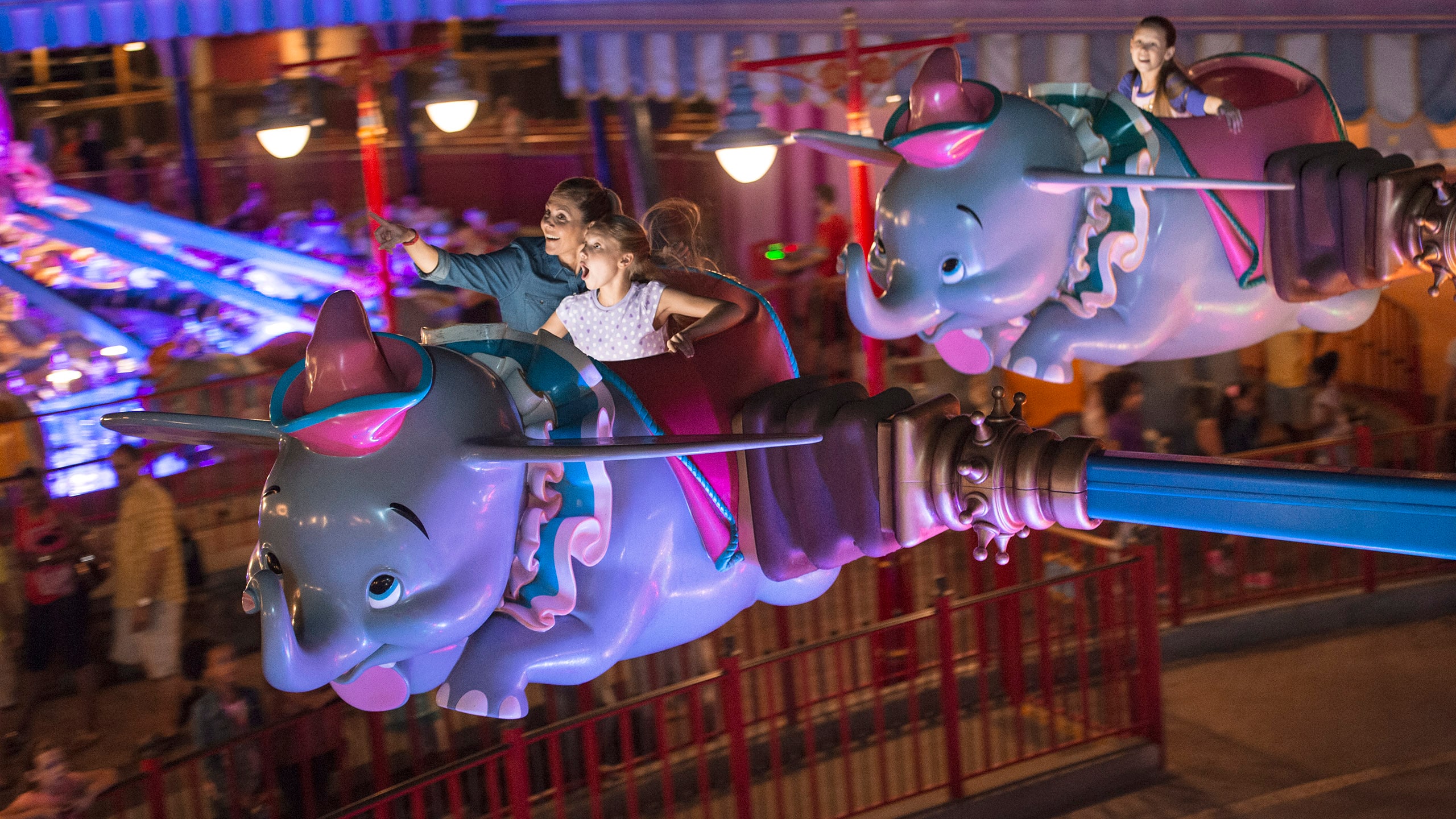 A mother and daughter on the Dumbo the Flying Elephant attraction at Magic Kingdom park
