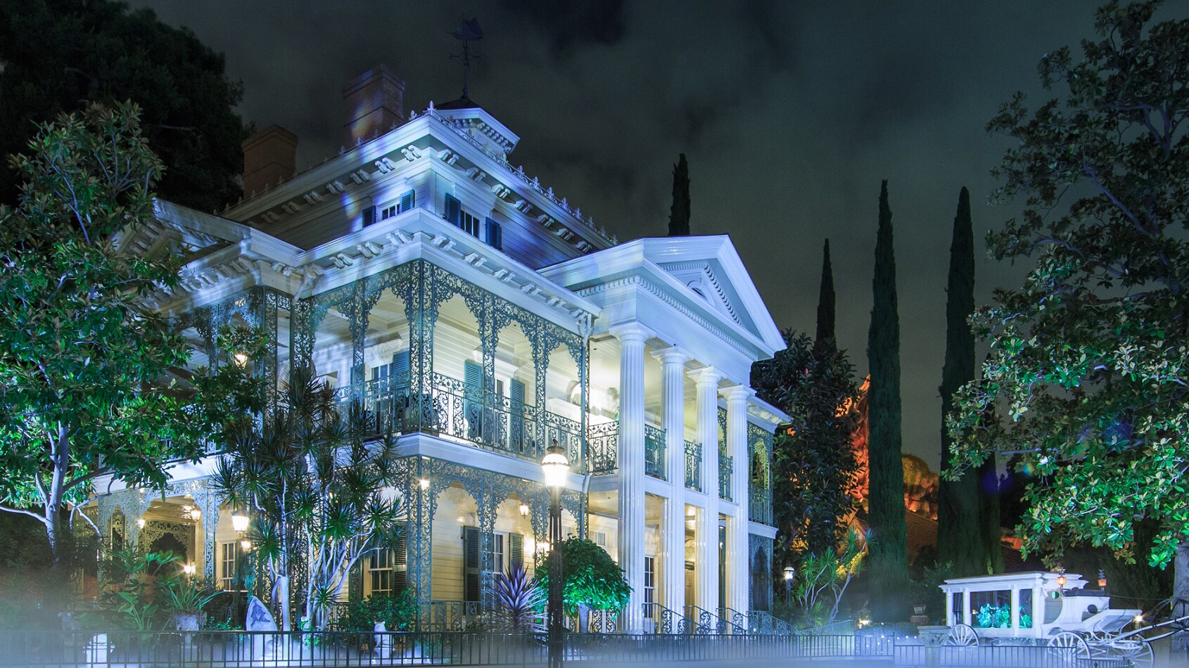 The Haunted Mansion attraction at Disneyland Park surrounded by fog at night