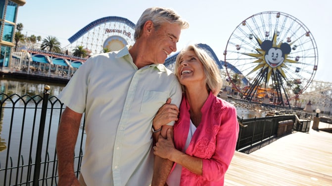 A couple walking arm-in-arm in the Paradise Pier area at Disney California Adventure Park