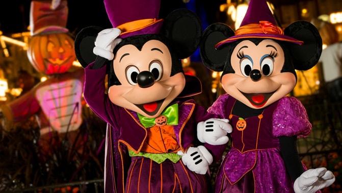 Mickey and Minnie Mouse dressed in Halloween-themed clothing