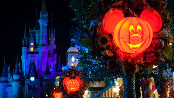 Mickey Mouse jack-o-lanterns illuminated at night near Cinderella Castle at Magic Kingdom park