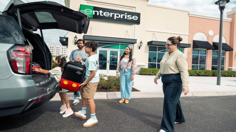 Family loading luggage into their rental car at an Enterprise location