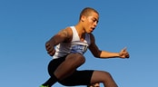 AAU Track and Field Club Championships A steeplechase runner jumps over a wooden barrier before his competitors