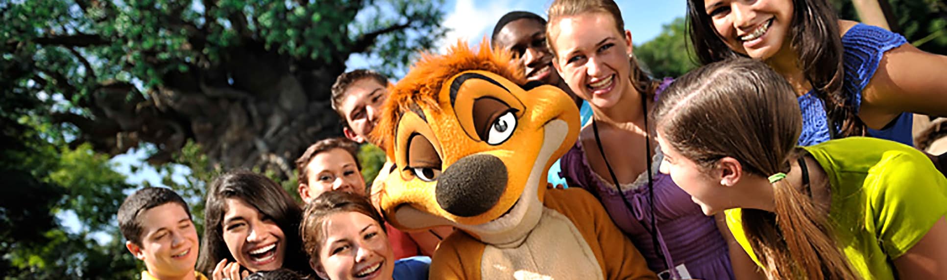 Young adults smile next to the Timon Character