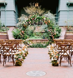 An outdoor wedding ceremony setup with a circular floral arch and flower lined aisle at Disney's Grand Californian Hotel and Spa